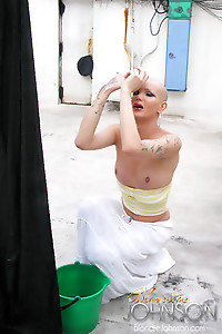 Bald tranny hanging clothes and stroking her shecock